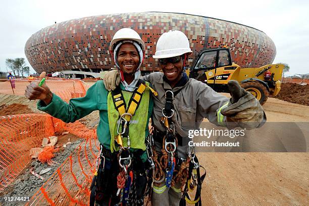 In this handout image provided by the 2010 FIFA World Cup Organising Committee South Africa, workers smile and give a thumbs up during the FIFA...