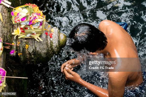 印尼巴厘島 tirta empul 寺水龍下的男子沐浴 - tampaksiring 個照片及圖片檔