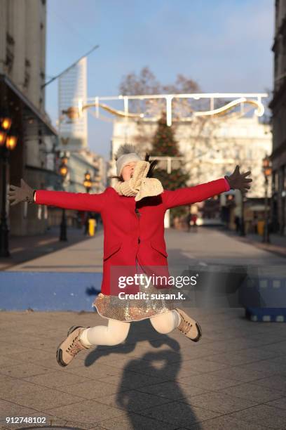 young girl wearing dress jumping mid-air on the street. - budapest people stock pictures, royalty-free photos & images