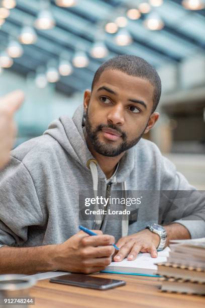 hübscher afro amerikanische universität studierender allein in einer campusbibliothek - delft stock-fotos und bilder