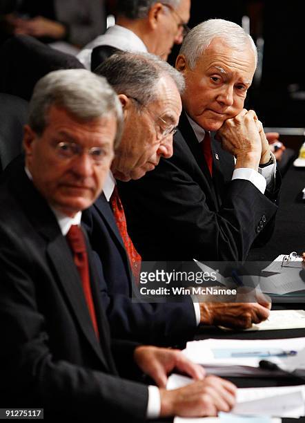 Sen. Orrin Hatch listens to committee Chairman Max Baucus while trying to introduce an amendment during a markup hearing of the Senate Finance...
