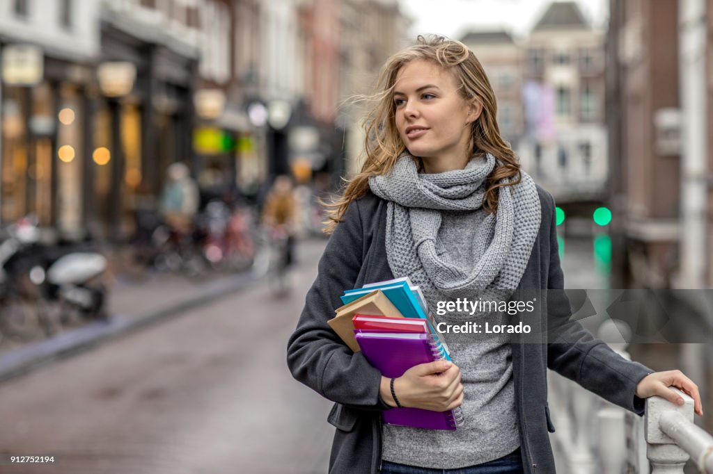 Beautiful female university student studying outdoors in delft city centre