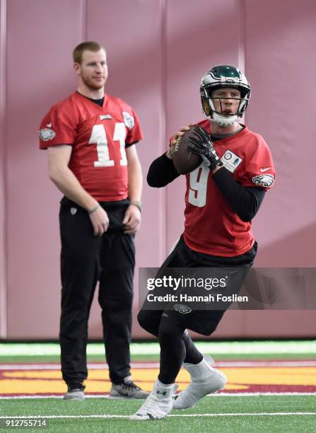 Carson Wentz of the Philadelphia Eagles looks on as teammate Nick Foles passes the ball during Super Bowl LII practice on January 31, 2018 at the...