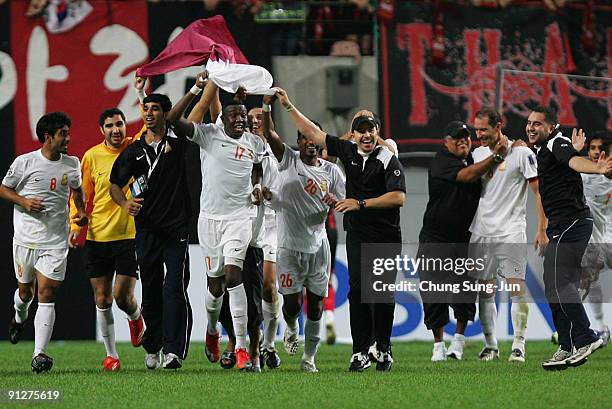 Umm Salal's players with a Qatar national flag celebrate after winning their AFC Champions League match between FC Seoul and Umm-Salal at Seoul World...