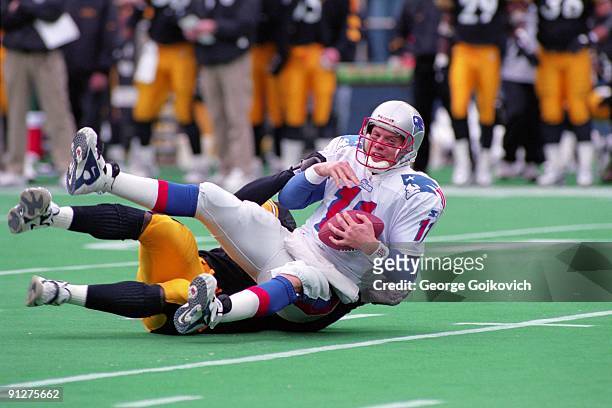 Quarterback Drew Bledsoe of the New England Patriots falls to the turf as he is sacked by linebacker Jason Gildon of the Pittsburgh Steelers during a...