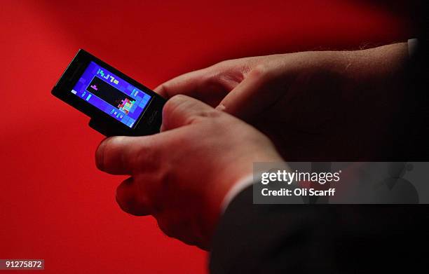 Delegate plays a game of tetris on his mobile phone during the speeches on the fourth day of the Labour Party Conference on September 30, 2009 in...