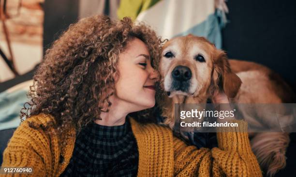 donna coccola con il suo cane - pets foto e immagini stock