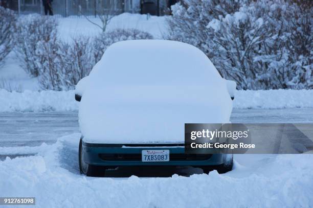 Light dusting of snow from a fast-moving overnight storm coats a parked vehicle at the Riva Grill Boat Marina on January 25 in South Lake Tahoe,...