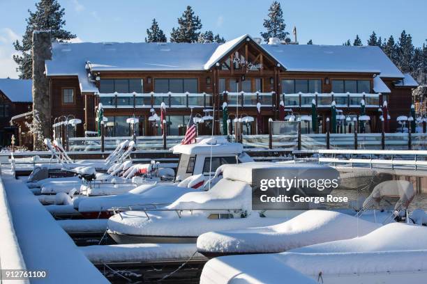 Light dusting of snow from a fast-moving overnight storm coats the Riva Grill Boat Marina on January 25 in South Lake Tahoe, California. Though a...