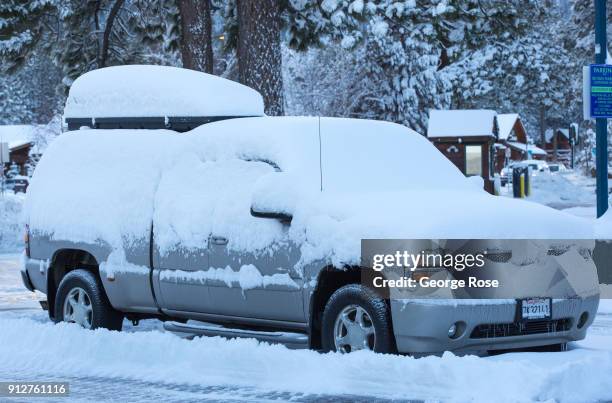 Light dusting of snow from a fast-moving overnight storm coats a parked vehicle at the Riva Grill Boat Marina on January 25 in South Lake Tahoe,...
