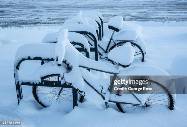 Light dusting of snow from a fast-moving overnight storm coats two bicycles at the Riva Grill Boat Marina on January 25 in South Lake Tahoe,...