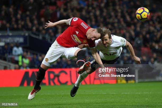 Phil Jones of Manchester United and Harry Kane of Tottenham Hotspur both dive to win a header during the Premier League match between Tottenham...