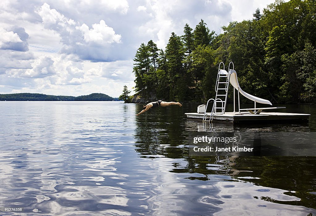 Woman dives into lake.