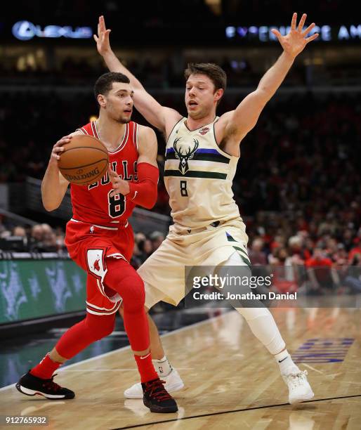 Zach LaVine of the Chicago Bulls looks to pass against Matthew Dellavedova of the Milwaukee Bucks at the United Center on January 28, 2018 in...
