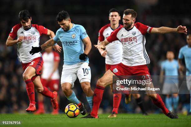 Sergio Aguero of Manchester City is challenged by Gareth McAuley of West Bromwich Albion and Claudio Yacob of West Bromwich Albion during the Premier...