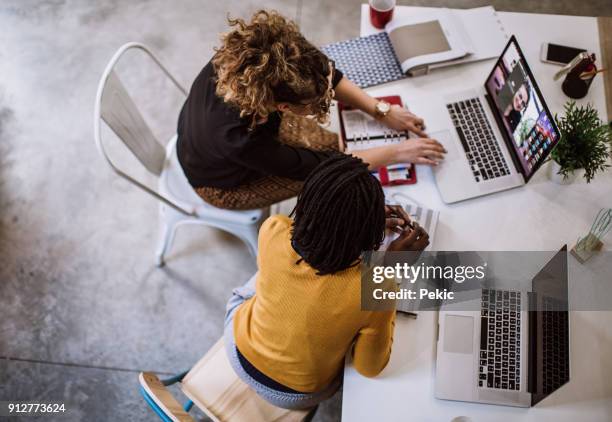 female coworkers using laptops - outsourcing stock pictures, royalty-free photos & images