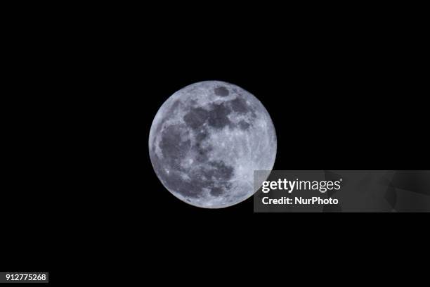 The 'supermoon' is pictured rising over London on January 31, 2018. Supermoons happen when a full moon approximately coincides with the moon's...