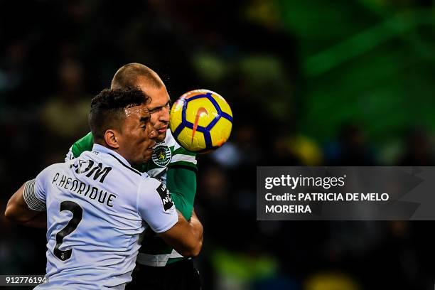 Sporting's Dutch forward Bas Dost heads the ball with Guimaraes' Brazilian defender Pedro Henrique during the Portuguese League football match...