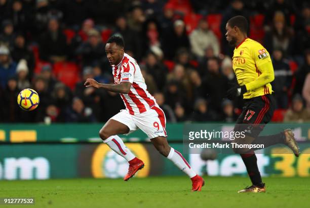 Saido Berahino of Stoke City runs with the ball under pressure from Jerome Sinclair of Watford during the Premier League match between Stoke City and...