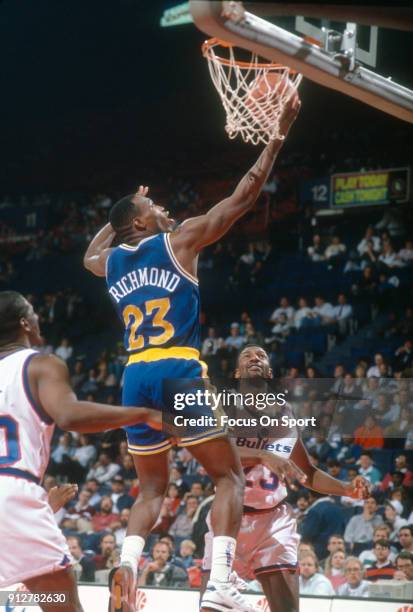 Mitch Richmond of the Golden State Warriors goes in for a layup against the Washington Bullets during an NBA basketball game circa 1990 at the...