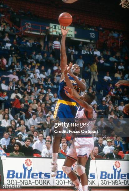 Mitch Richmond of the Golden State Warriors shoots over Darryl Walker of the Washington Bullets during an NBA basketball game circa 1990 at the...