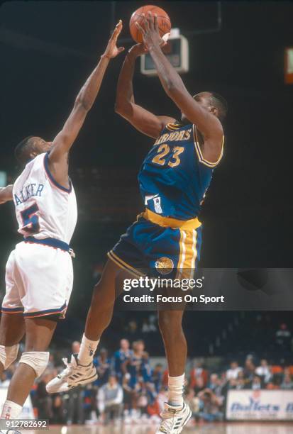 Mitch Richmond of the Golden State Warriors shoots over Darryl Walker of the Washington Bullets during an NBA basketball game circa 1990 at the...