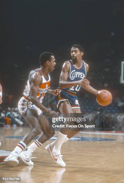 Norm Nixon of the San Diego Clippers dribbles the ball while guarded by Frank Johnson of the Washington Bullets during an NBA basketball game circa...