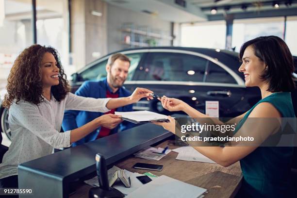 pareja se compra coche nuevo y firmar el contrato - car ownership fotografías e imágenes de stock
