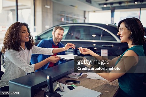 Couple is buying new car and signing the contract Couple is buying new car and signing the contract