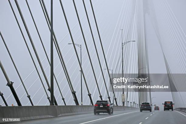 highway traffic on port mann bridge in metro vancouver, canada, in winter - surrey british columbia stock pictures, royalty-free photos & images