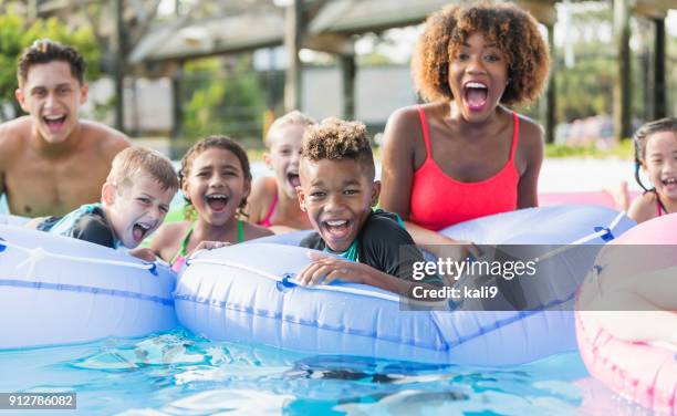 multi-etnische kinderen en jonge volwassenen op waterpark - poolparty stockfoto's en -beelden