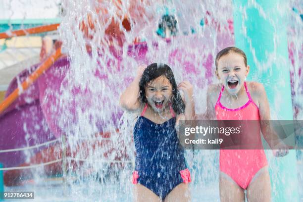 two girls getting drenched at water park - water park stock pictures, royalty-free photos & images