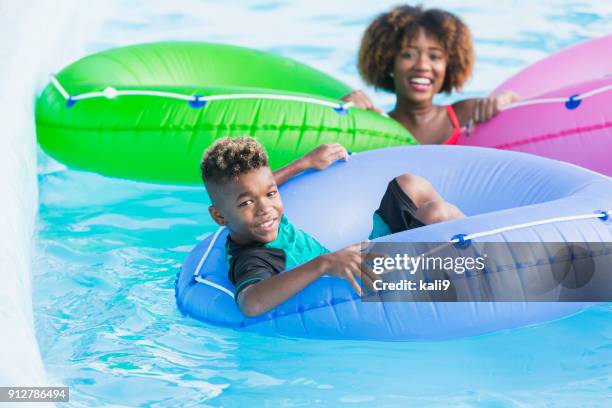 mixed race boy having fun at water park on lazy river - lazy river stock pictures, royalty-free photos & images