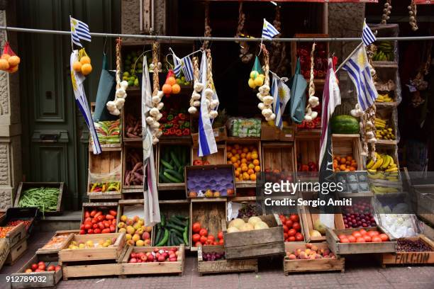 crates of fruits and vegetables, garlic braids and uruguayan flags - en chapelet photos et images de collection