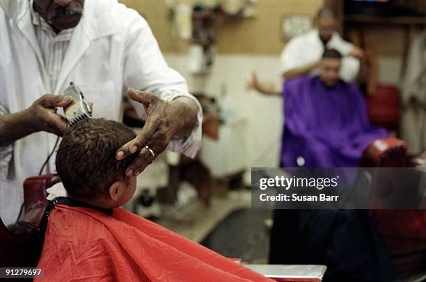 boy getting hair cut in barber shop - barber shop 3 stock pictures, royalty-free photos & images