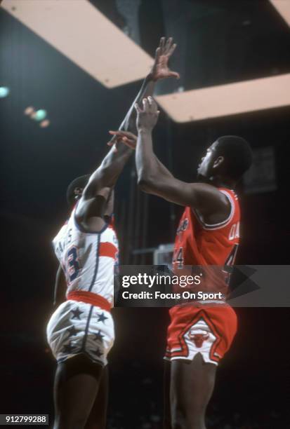 Quintin Dailey of the Chicago Bulls shoots over Charles Davis of the Washington Bullets during an NBA basketball game circa 1982 at the Capital...