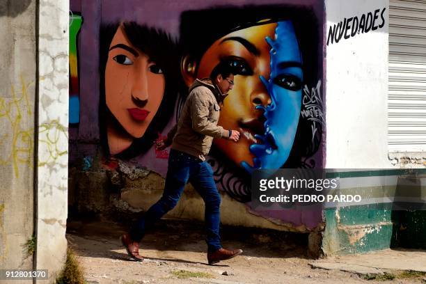 Man walks past a graffiti in Tenancingo, Tlaxcala state, Mexico, on January 19, 2018. The most powerful pimps of Mexico have virtually built walls...