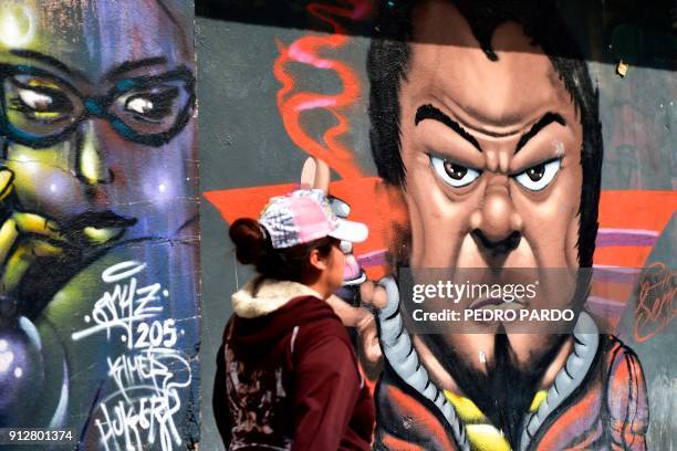 Woman walks past a graffiti in Tenancingo, Tlaxcala state, Mexico, on January 19, 2018. The most powerful pimps of Mexico have virtually built walls...