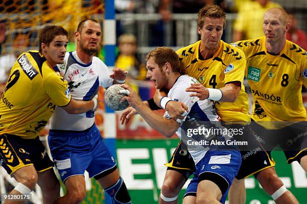 Steffen Weinhold of Grosswallstadt is challenged by Nikola Manojlovic , Oliver RoggisCH and Karol Bielecki of Rhein-Neckar Loewen during the...