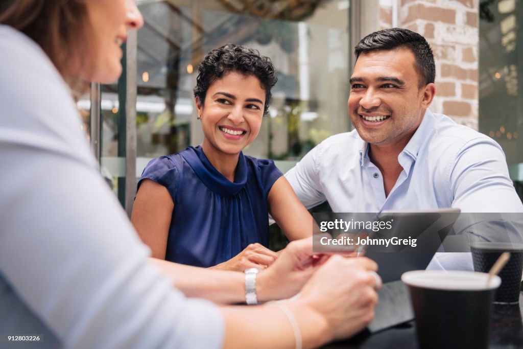 Happy couple receive good news from professional businesswoman