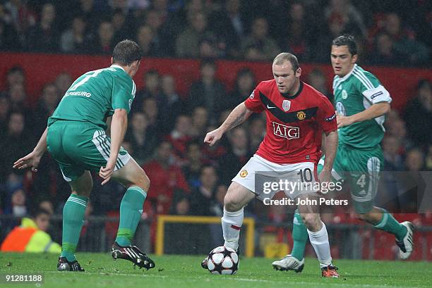 Wayne Rooney of Manchester United clashes with Alexander Madlung of Wolfsburg during the UEFA Champions League match between Manchester United and...