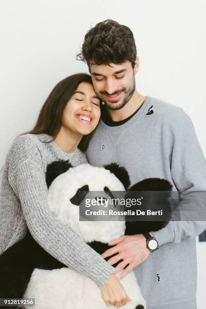 glückliches junges paar stehend umarmt ein kuscheltier - couple portrait soft stock-fotos und bilder