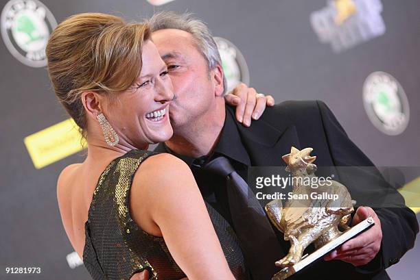 Actor Wolfgang Stumph holds his Goldene Henne Award while kissing actress Suzanne von Borsody at the Goldene Henne 2009 awards at...