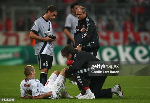 Arjen Robben of Bayern receives medical treatment by team doctor Hans-Wilhelm Mueller-Wohlfahrt after picking an injury during the UEFA Champions...