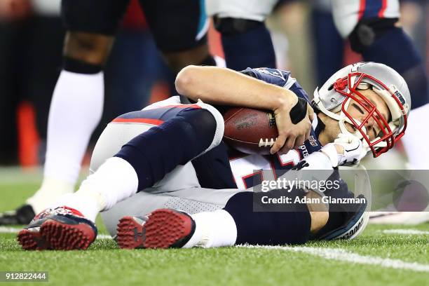 Tom Brady of the New England Patriots is knocked down in the fourth quarter during the AFC Championship Game against the Jacksonville Jaguars at...