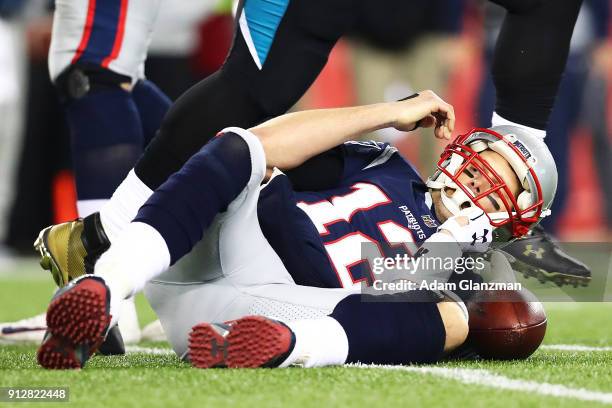 Tom Brady of the New England Patriots is knocked down in the fourth quarter during the AFC Championship Game against the Jacksonville Jaguars at...