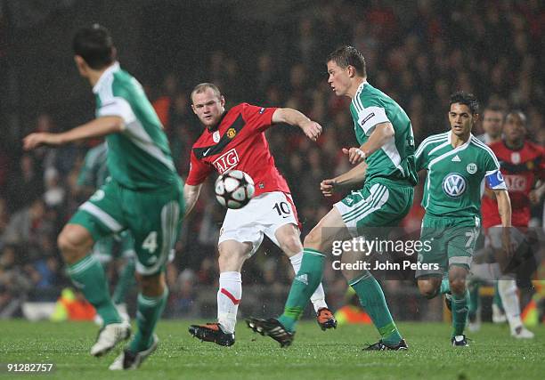 Wayne Rooney of Manchester United clashes with Alexander Madlung of Wolfsburg during the UEFA Champions League match between Manchester United and...