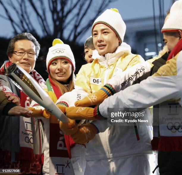 Actor Jang Keun Suk and former Olympic figure skater Miki Ando take part in the torch relay for the Pyeongchang Winter Olympics, in South Korea's...