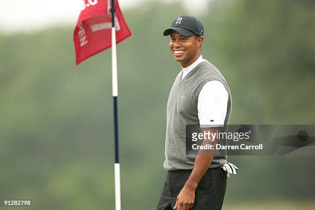 Tiger Woods smiles as he walks off the green during the continuation of the first round of the 109th U.S. Open Championship on the Black Course at...