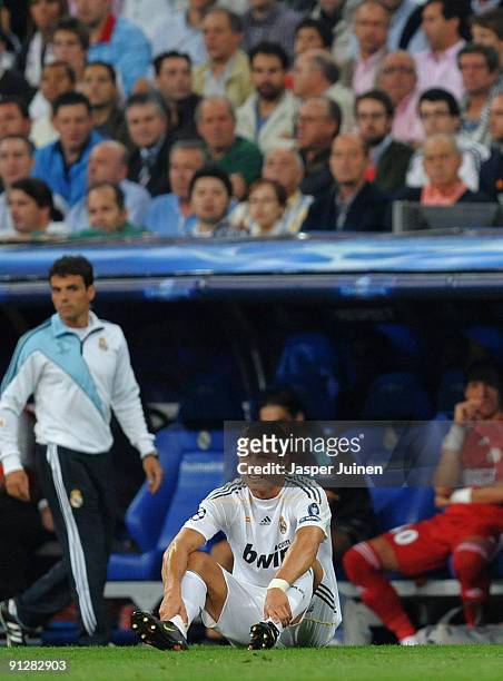 Cristiano Ronaldo of Real Madrid sits injured on the pitch shortly before leaving the pitch injured during the Champions League group C match between...